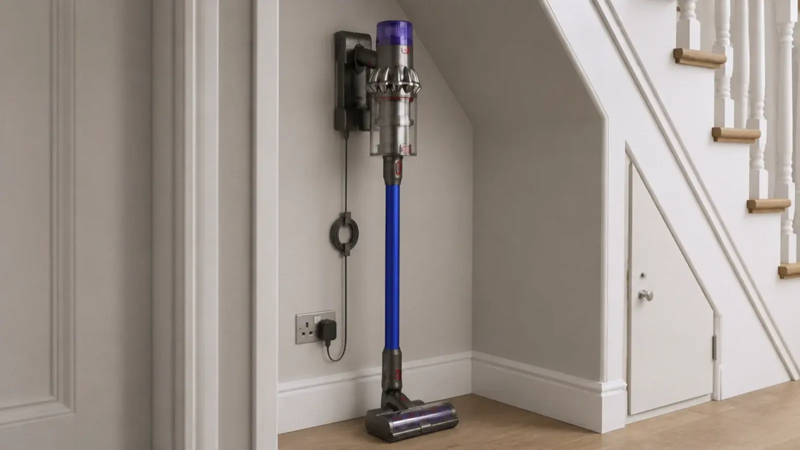 cordless vacuum docked on a bracket inside an under stairs recess