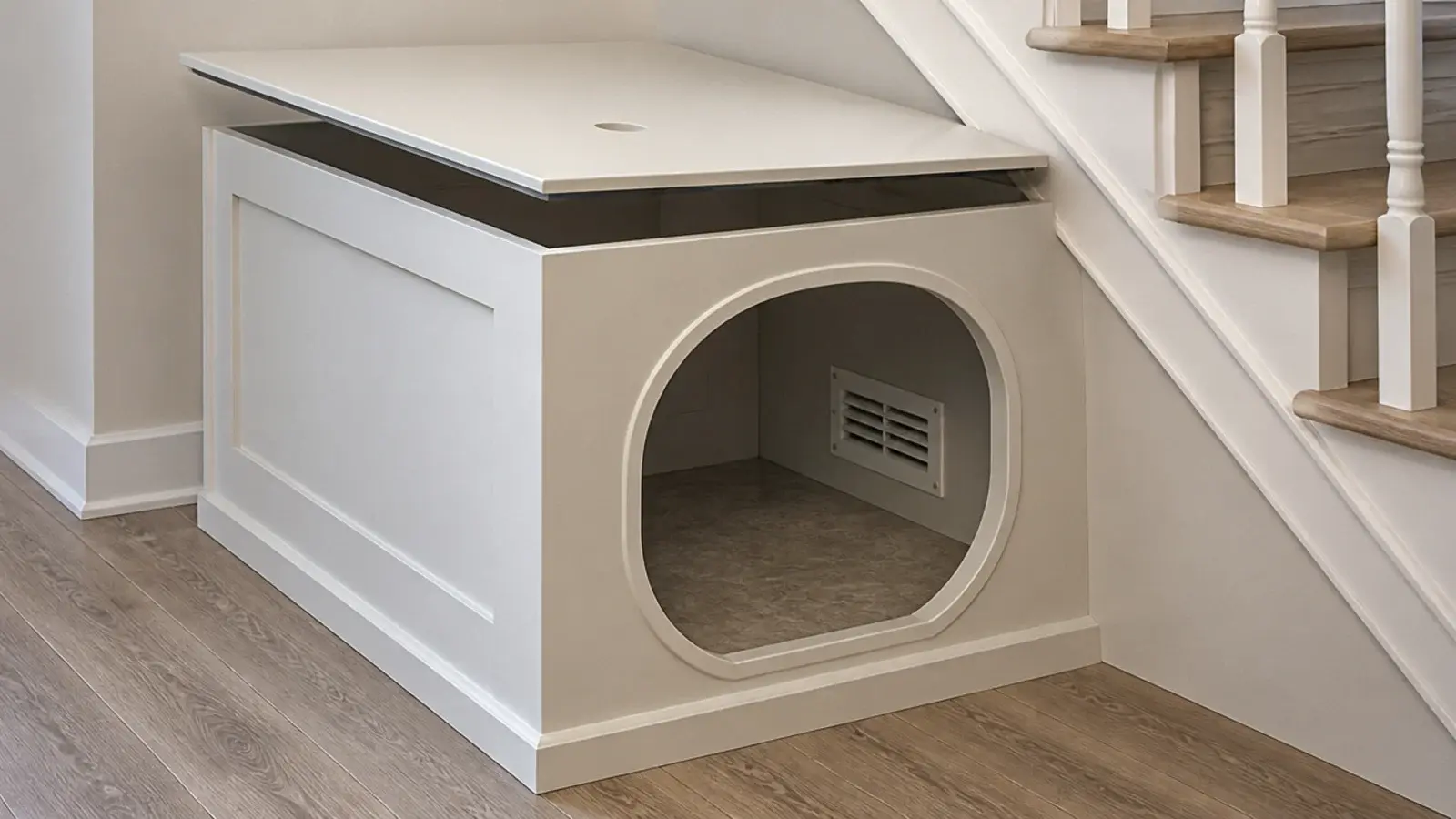 empty painted cabinet with a cat sized opening under a staircase