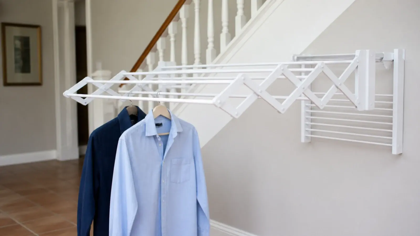 concertina drying rail folded out from a wall under the stairs