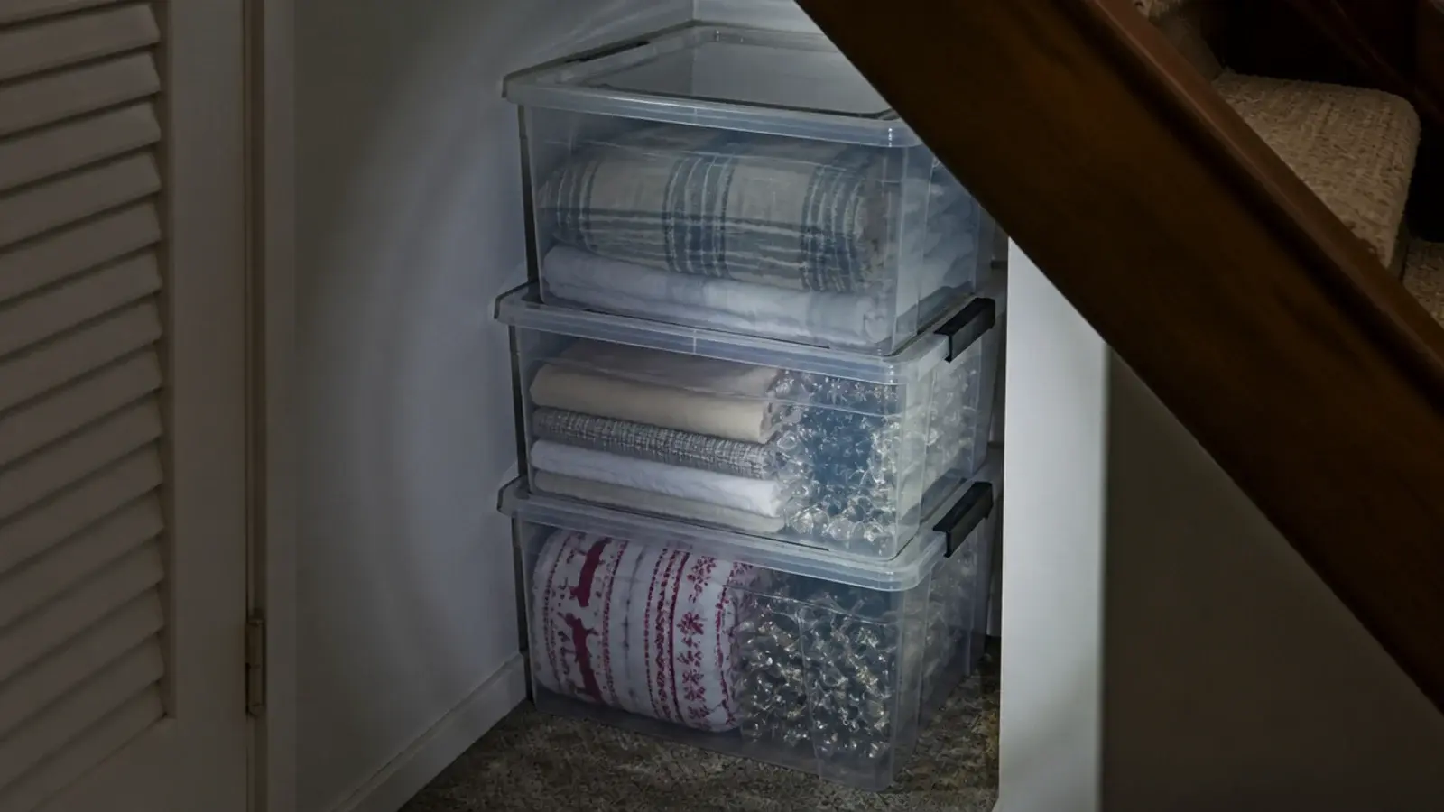 clear lidded storage boxes stacked in the tightest end of a staircase
