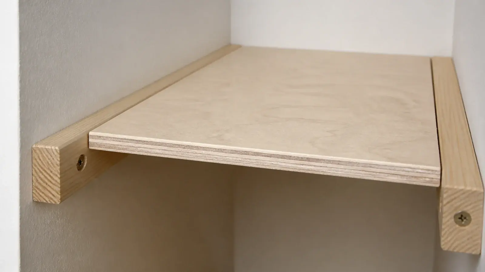 timber battens screwed to cupboard walls carrying a plywood shelf