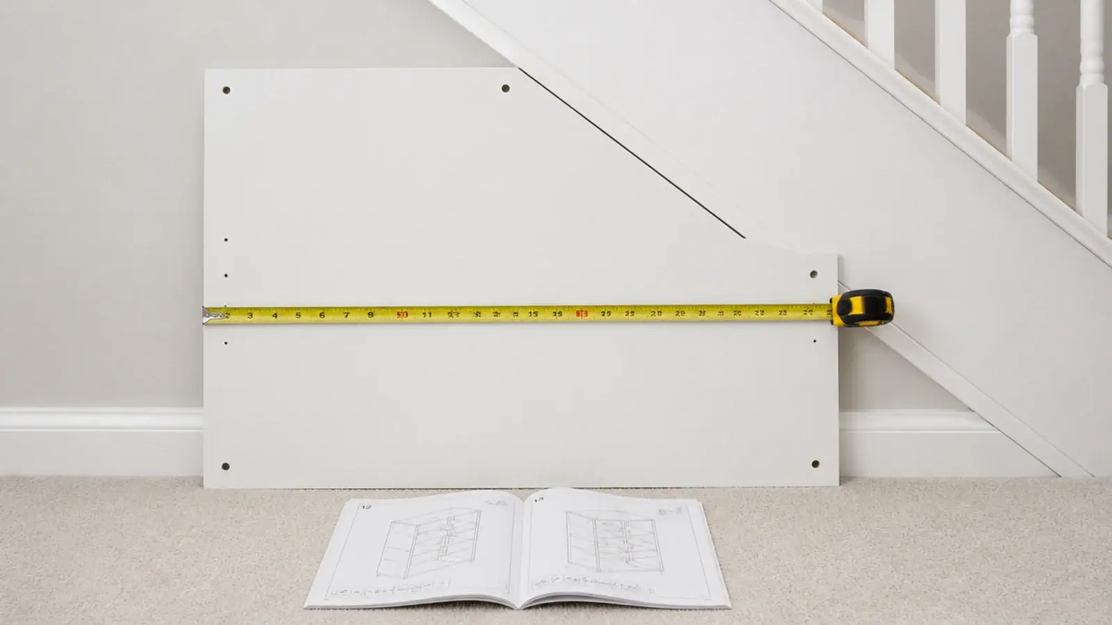 flat pack side panel held against a sloping stair soffit for measuring