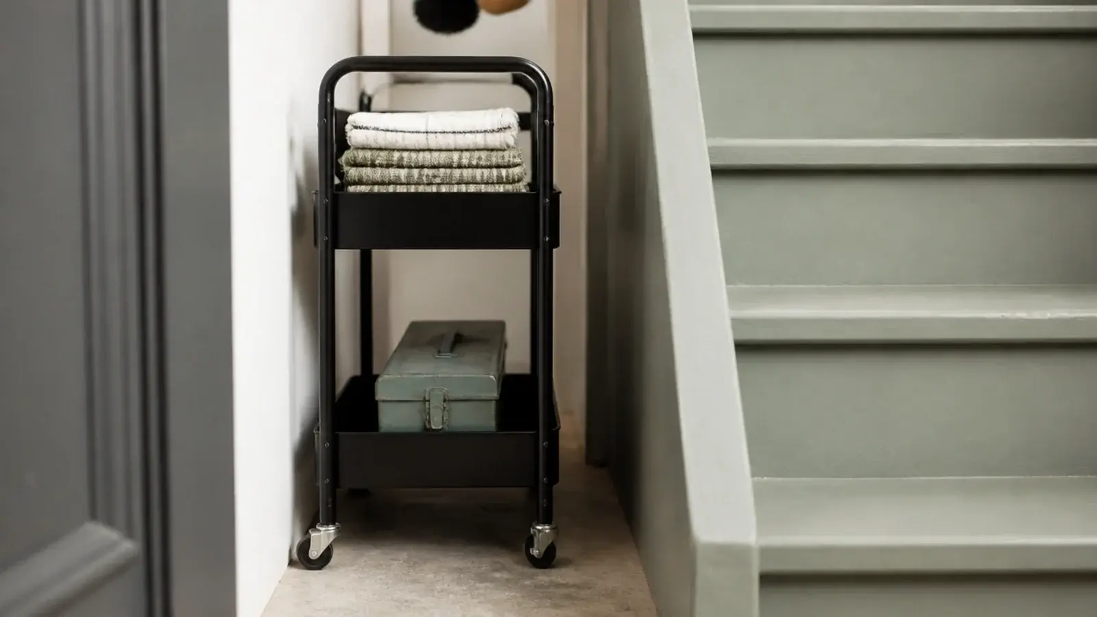 slim two tier trolley fitted into a narrow gap beside a staircase