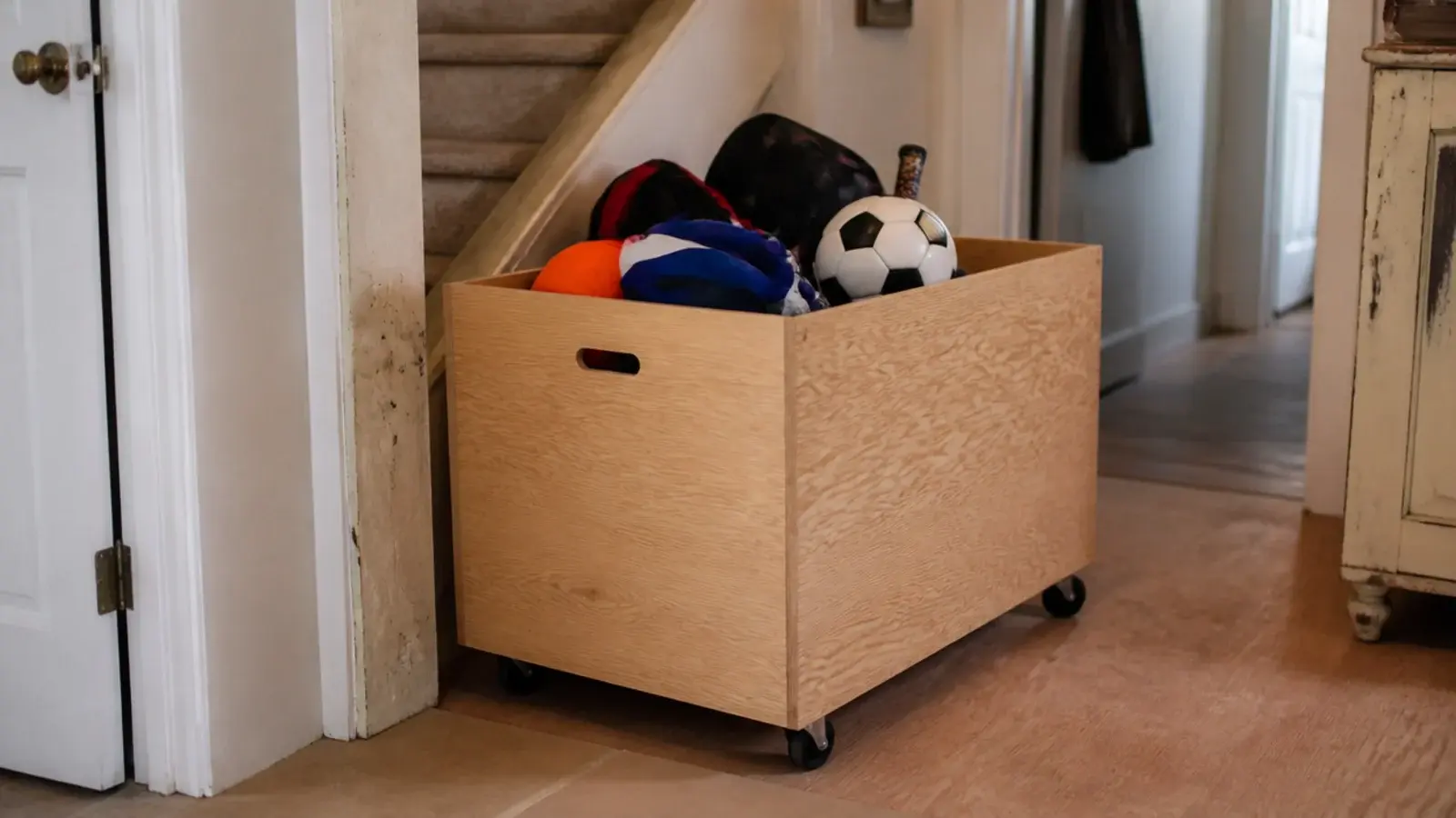 large timber box on castors rolled out from a staircase recess