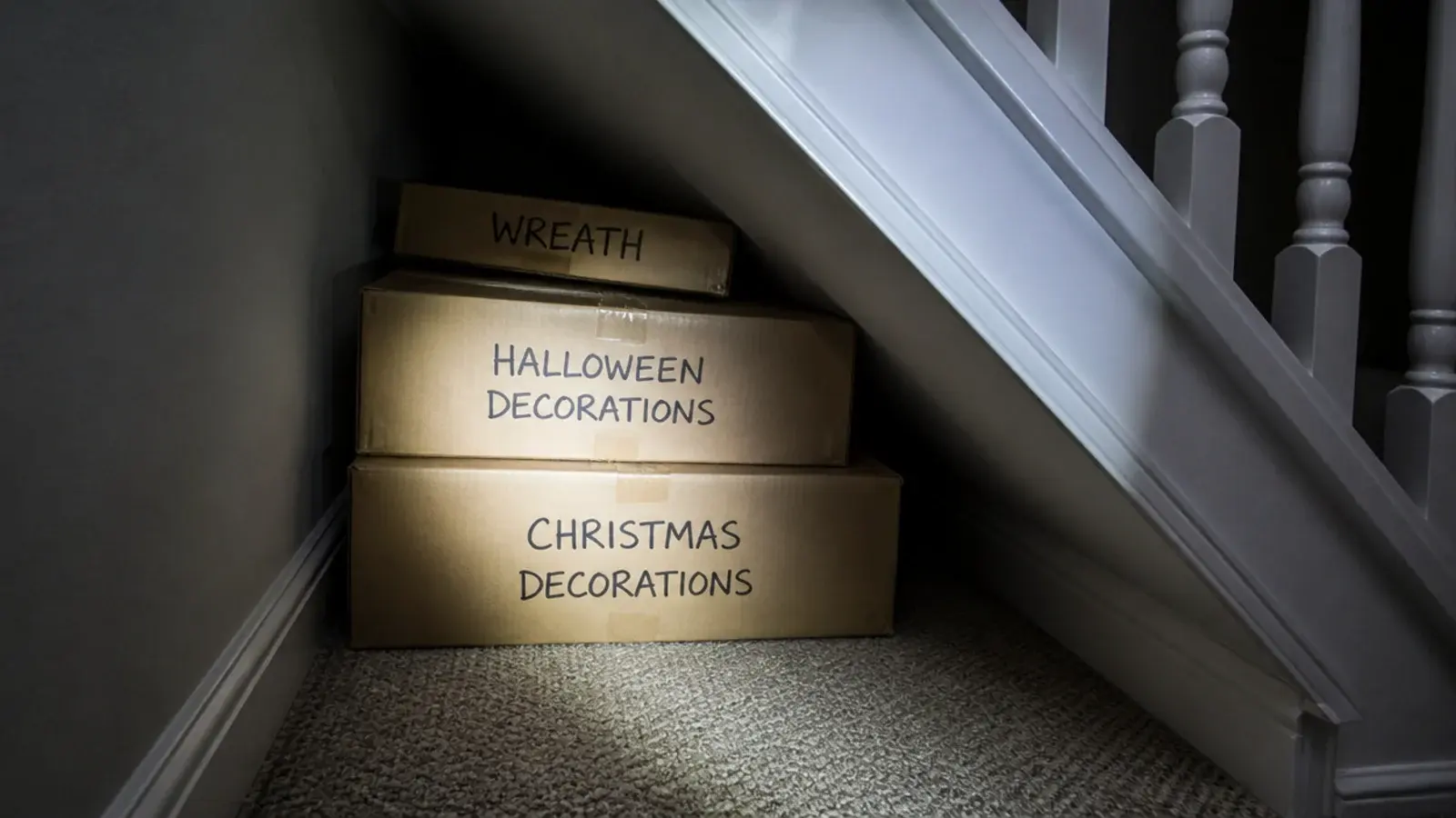 labelled seasonal boxes pushed to the deepest corner under stairs