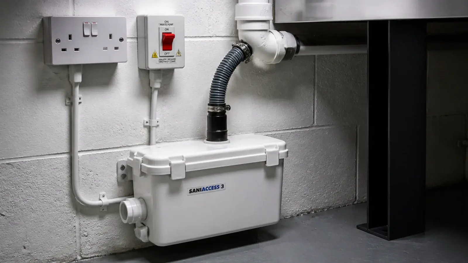 compact laundry waste pump mounted beside a machine on a cellar wall
