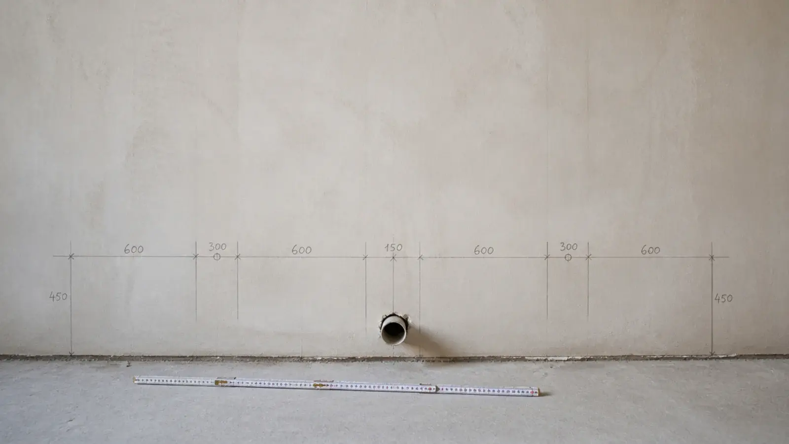 pencil marks setting out a cabinet run along a bare utility wall