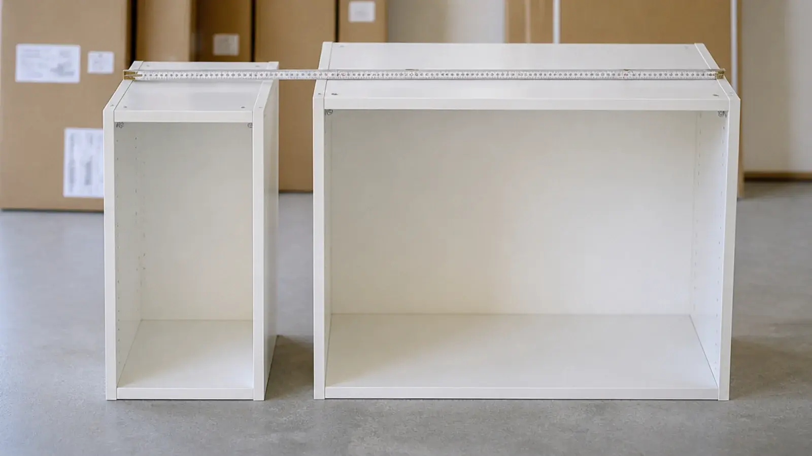 two cabinet carcasses of different depths standing side by side