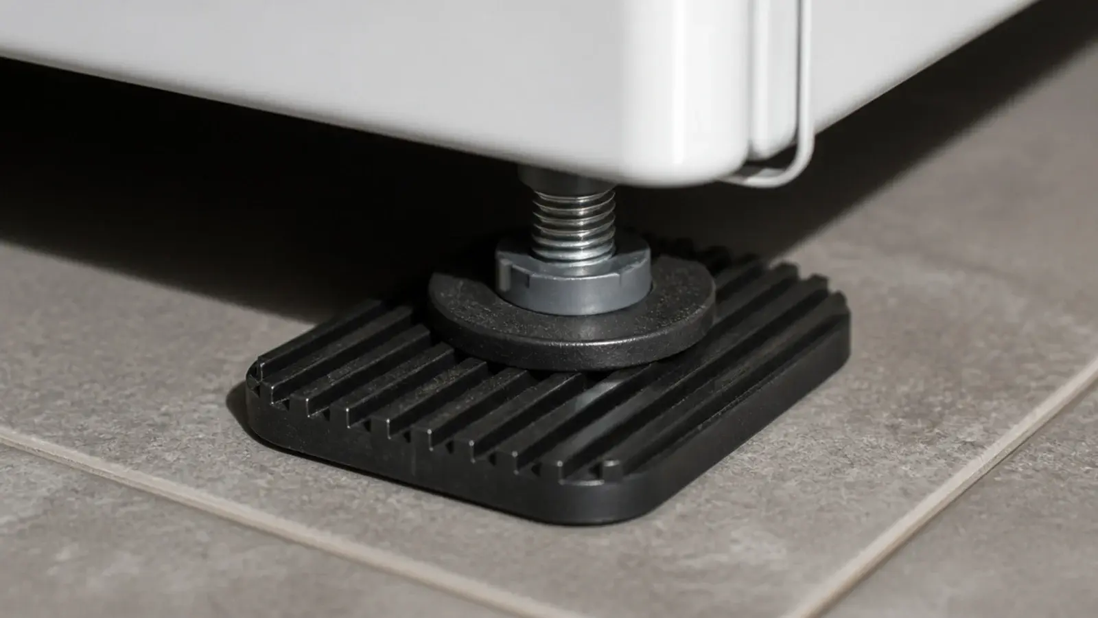 black rubber anti vibration pads under a washing machine foot