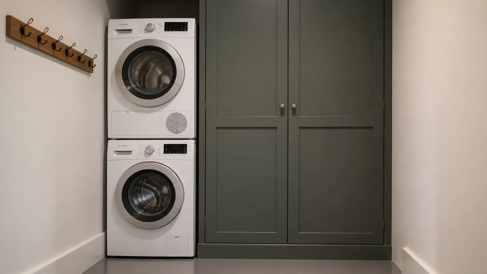 stacked machines beside a tall full height utility cupboard with doors closed