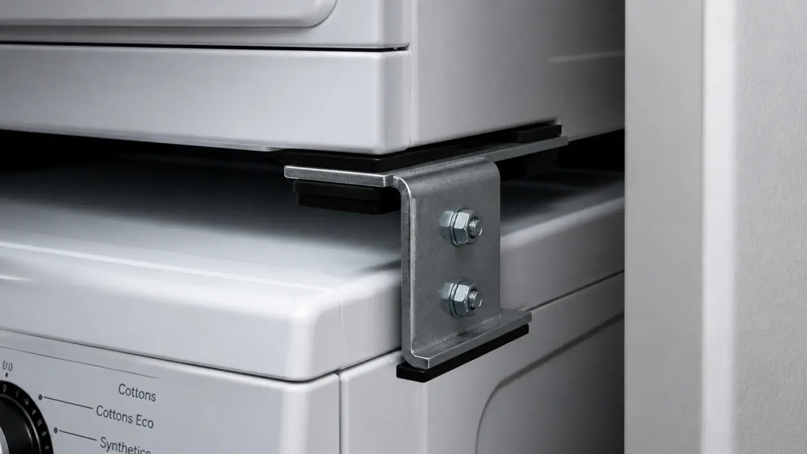 metal stacking bracket clamped between a front loading washer and dryer