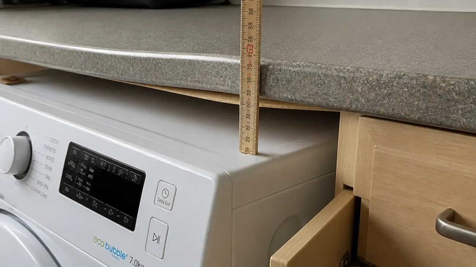 tape measure showing a machine too tall for the worktop above it
