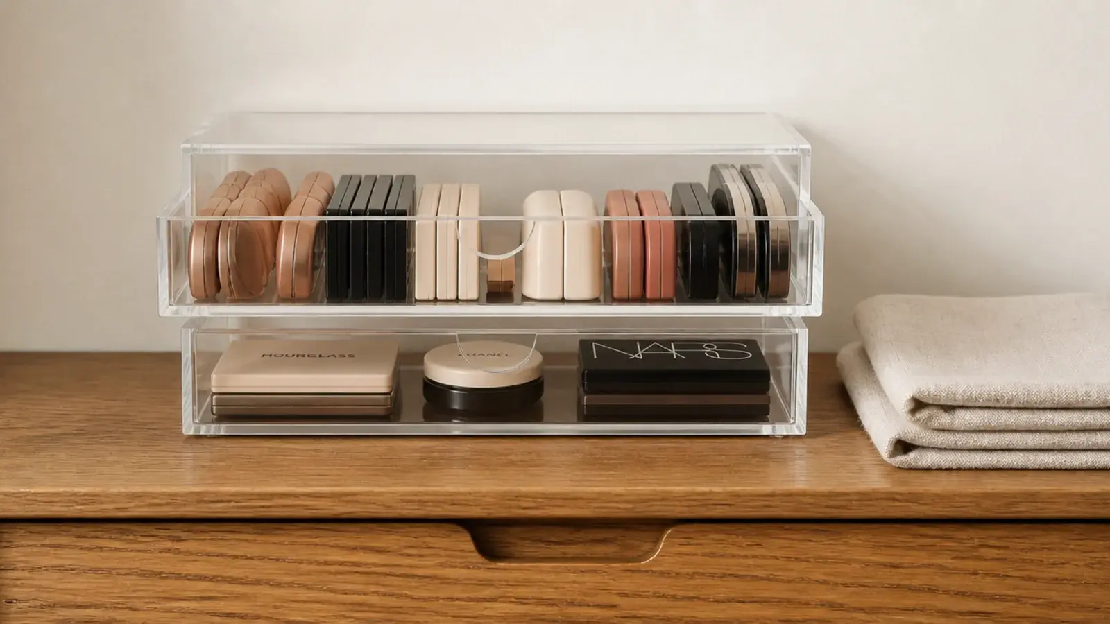 two small clear stacking drawers holding makeup on a narrow vanity