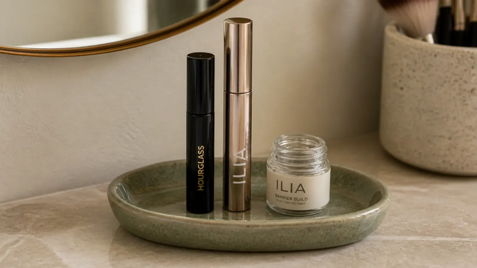 small dish collecting empty makeup containers beside a vanity mirror