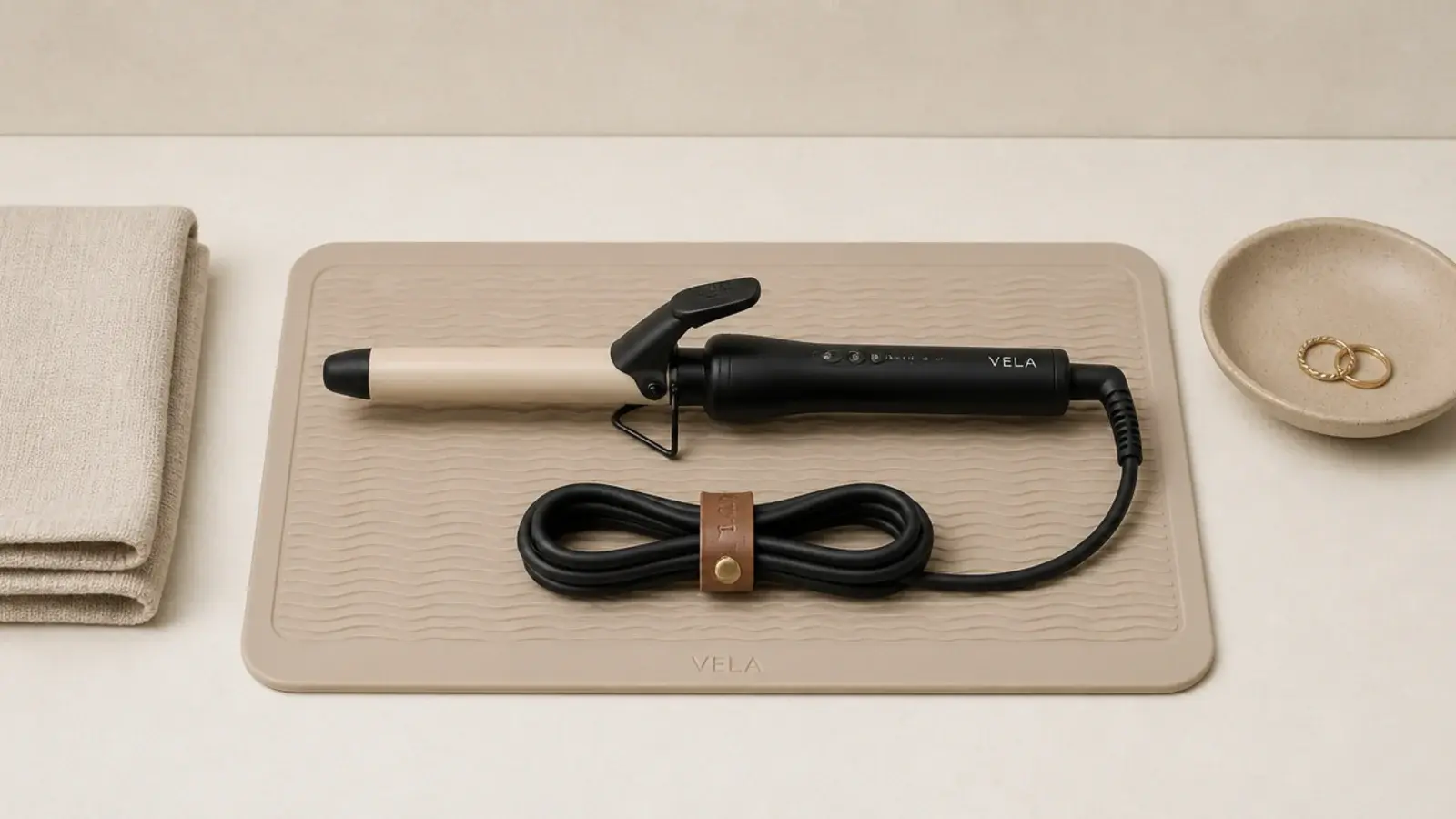 silicone heat mat holding a curling iron with the cord coiled neatly