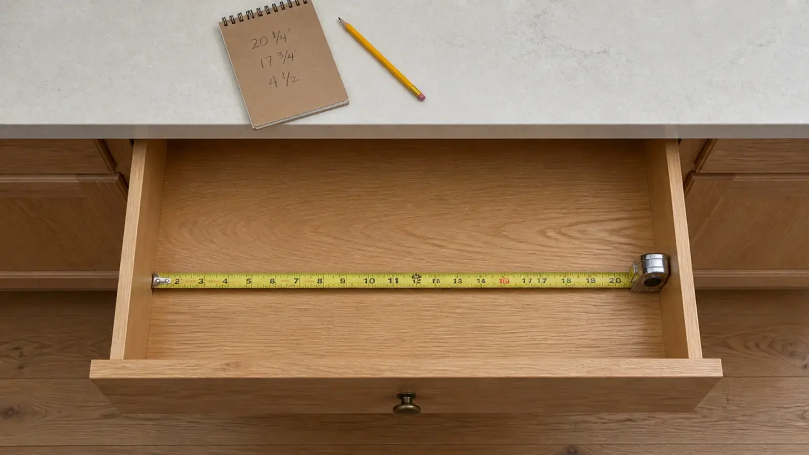 tape measure and notepad recording internal vanity drawer measurements