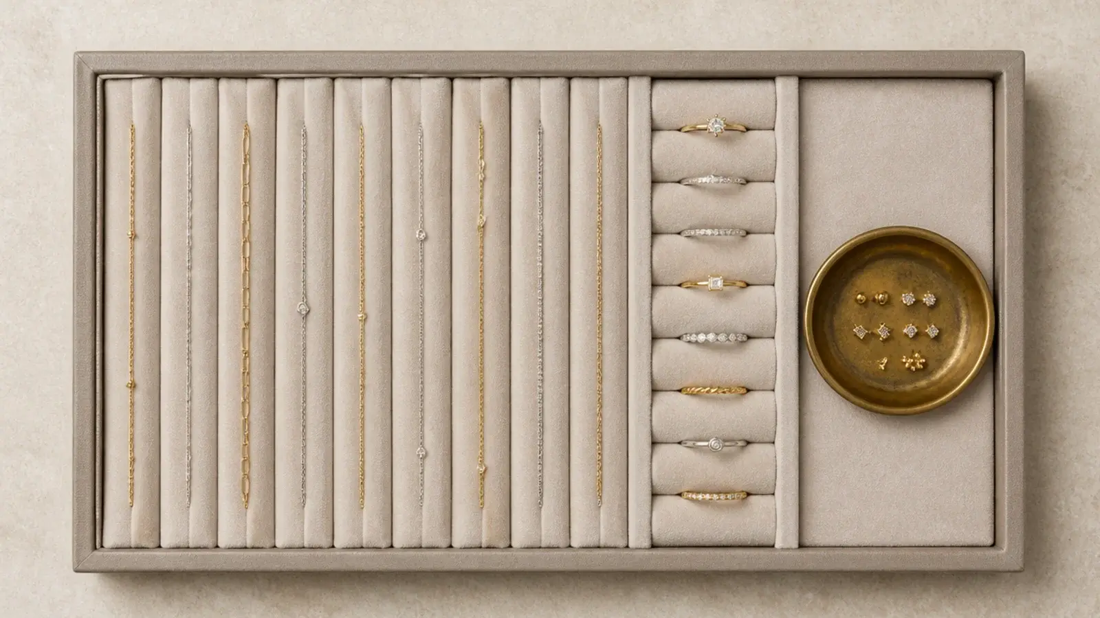 rings and chains laid in a slotted shallow jewellery drawer tray