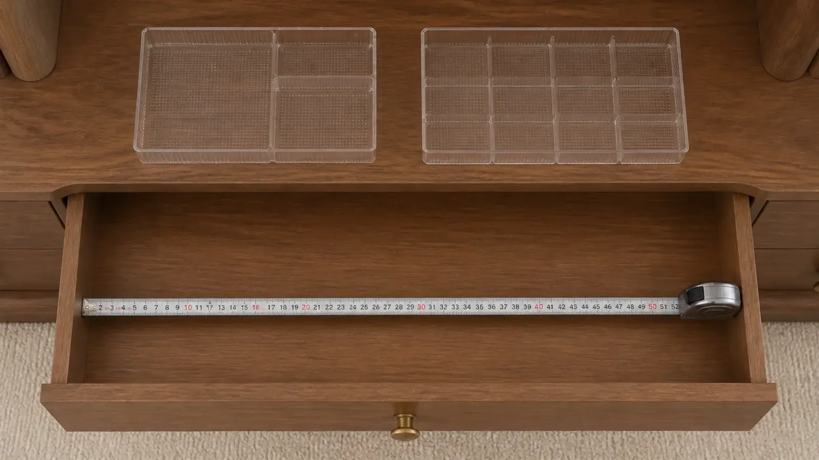 tape measure inside an open vanity drawer next to clear insert trays