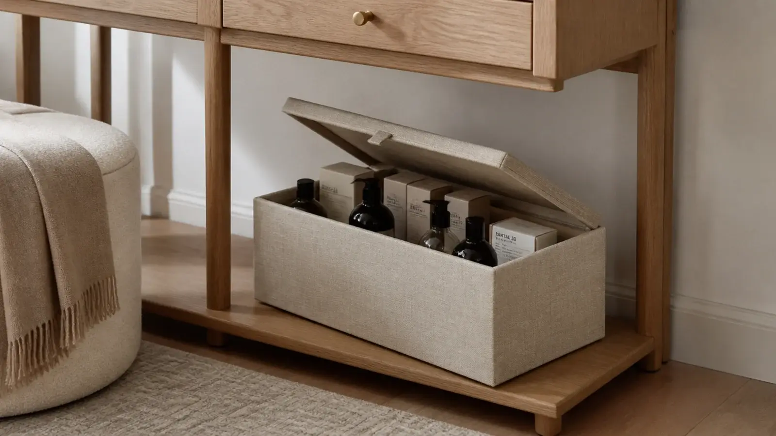 linen covered lidded box storing unopened skincare under a dressing table