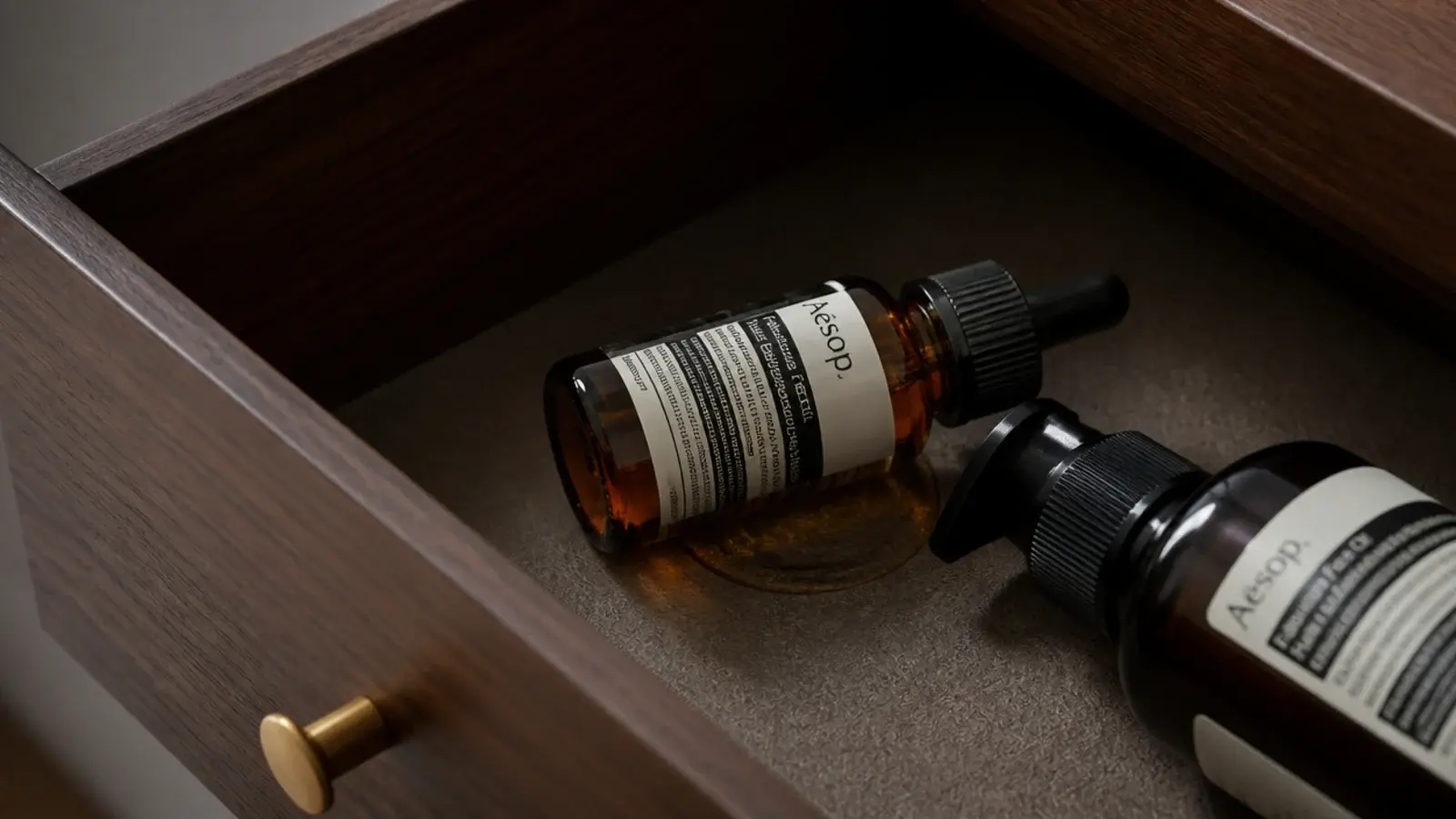 serum dropper lying flat in a drawer with a small oily leak beneath