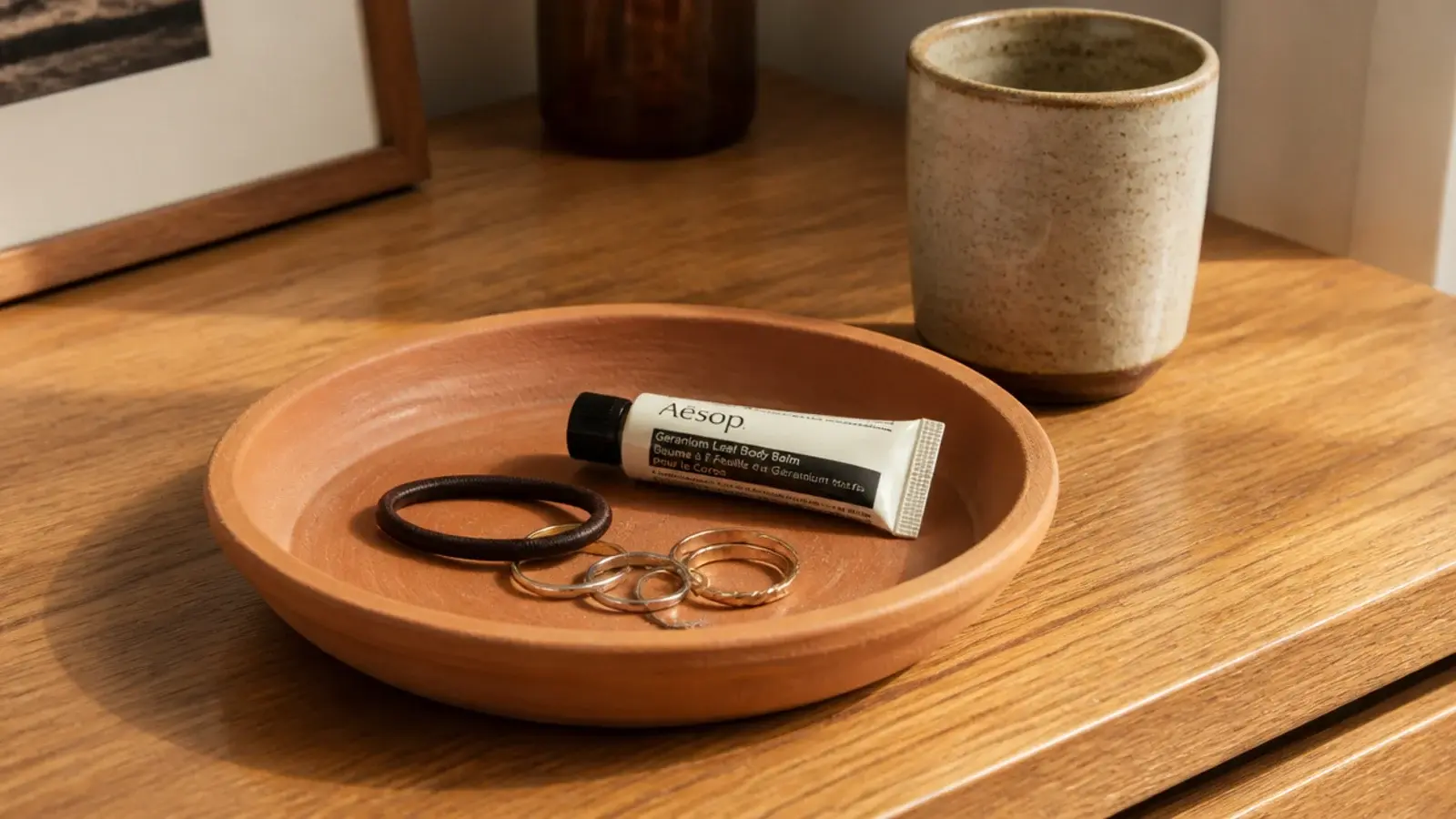 terracotta plant saucer used as a catch-all tray on a vanity