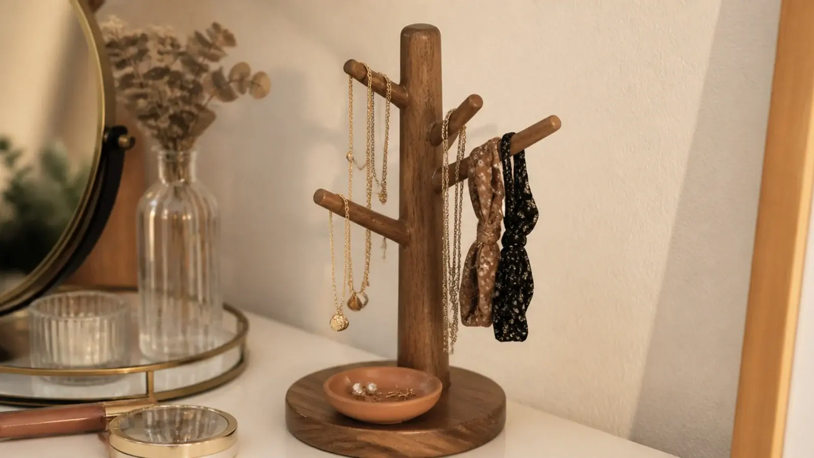 mug tree holding necklaces and hair ties beside a vanity mirror
