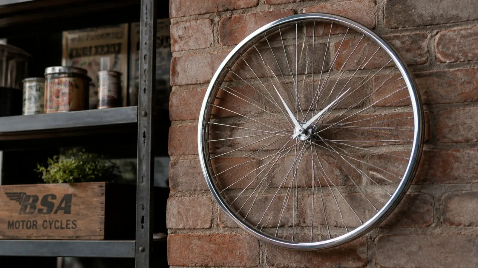 spoked bicycle rim clock hung against exposed brick and steel