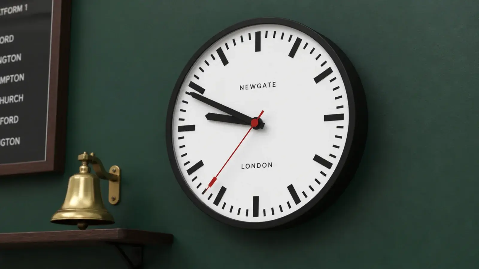 station clock with a bold red tipped second hand and dark numerals