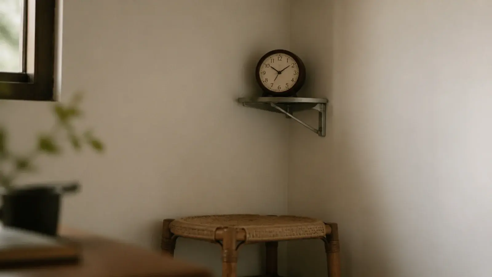 clock mounted on an angled bracket in an internal room corner