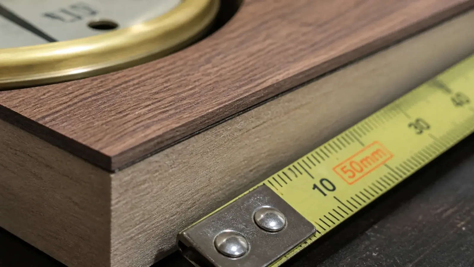 clock edge showing a fine dark glue line under a thin veneer