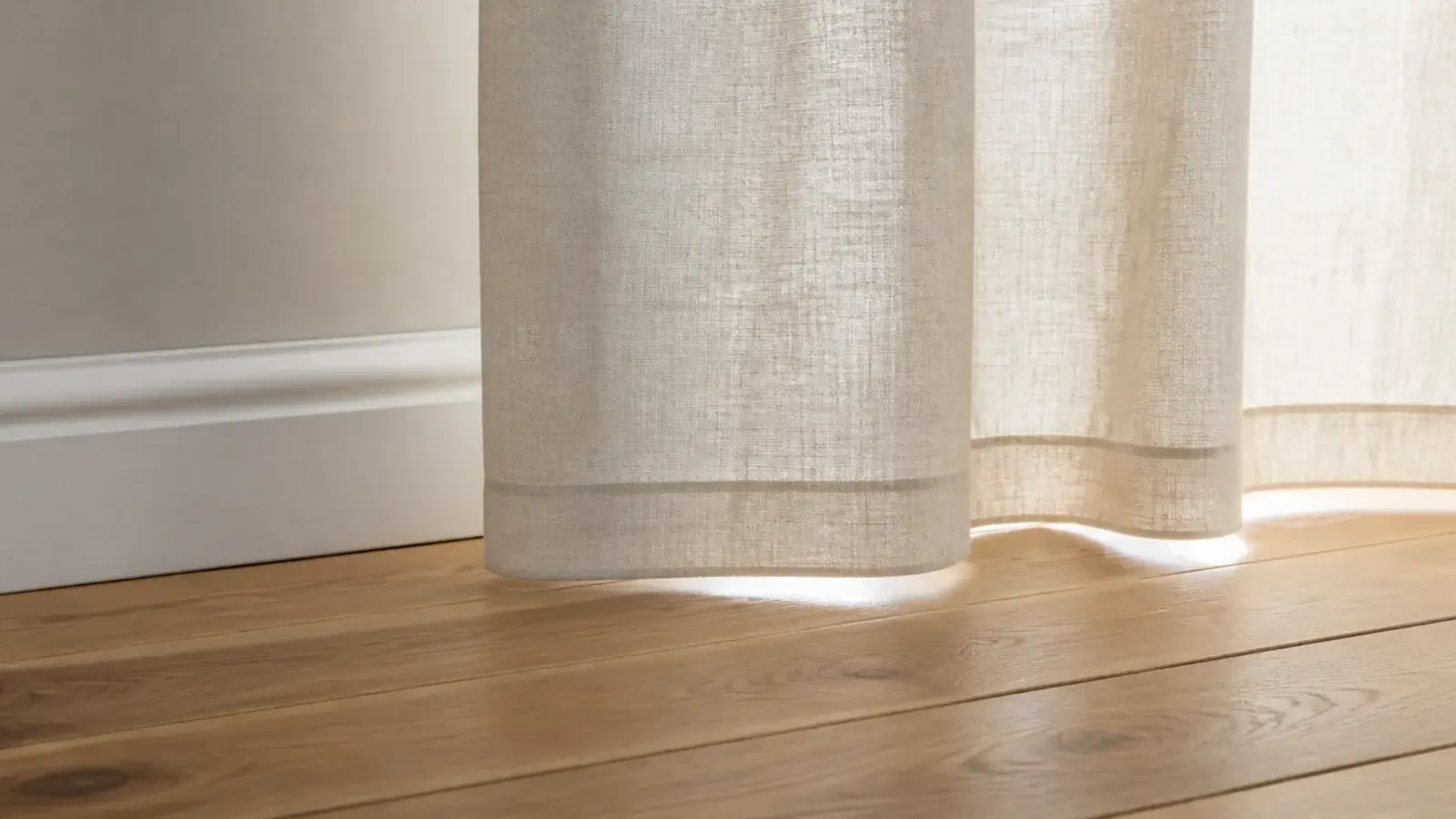 linen curtain hem hanging just clear of a timber bedroom floor