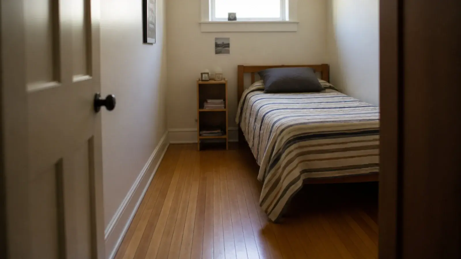 narrow oak strips filling a very small bedroom with many board runs