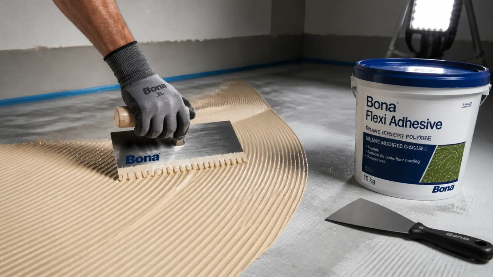 flexible parquet adhesive being combed into ridges with a notched trowel