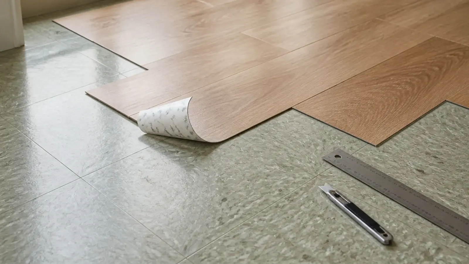 thin peel and stick wood effect planks laid over an old vinyl floor