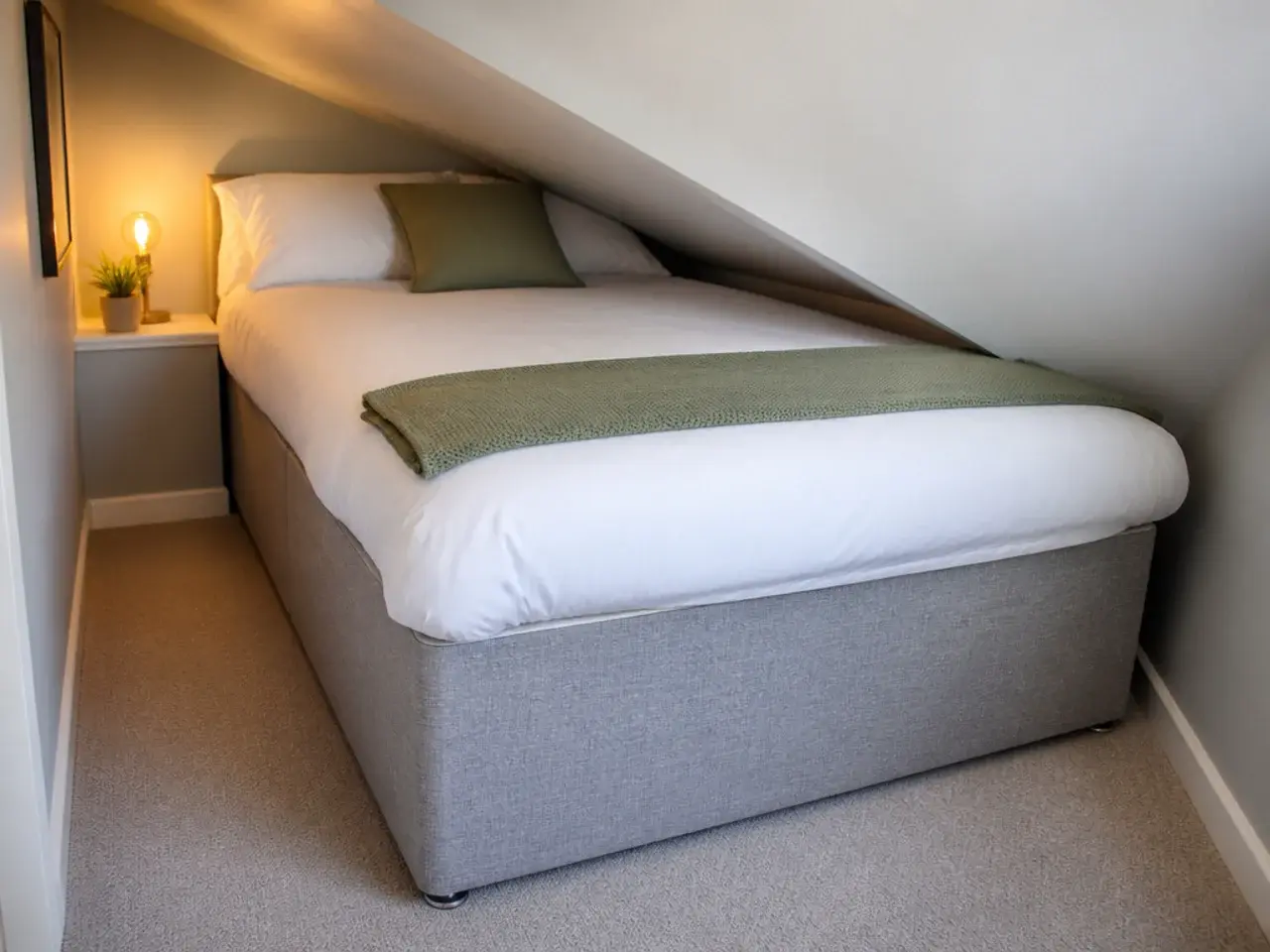 tall divan bed base sitting awkwardly under a low attic slope