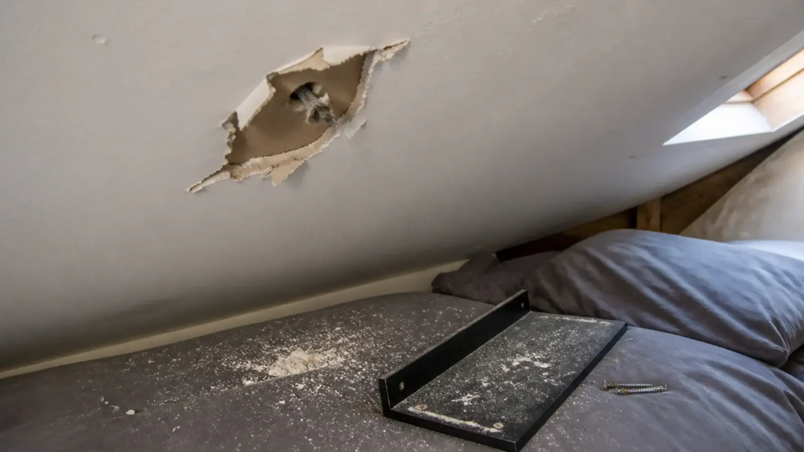 failed plasterboard fixing leaving a torn hole in an attic slope