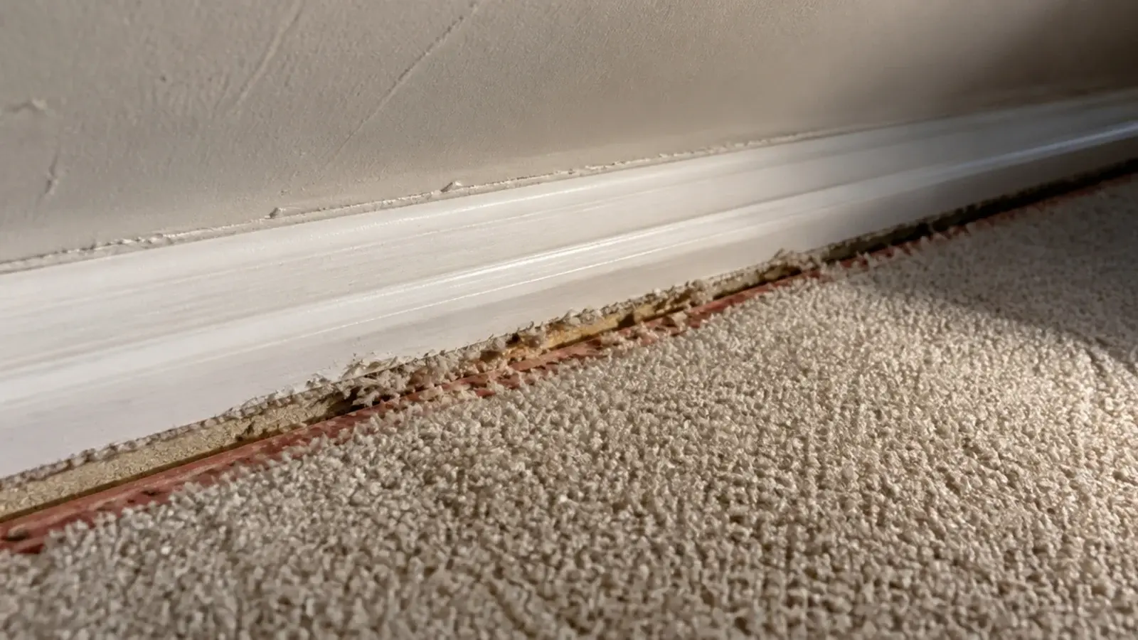 carpet edge fitted awkwardly against an attic knee wall corner