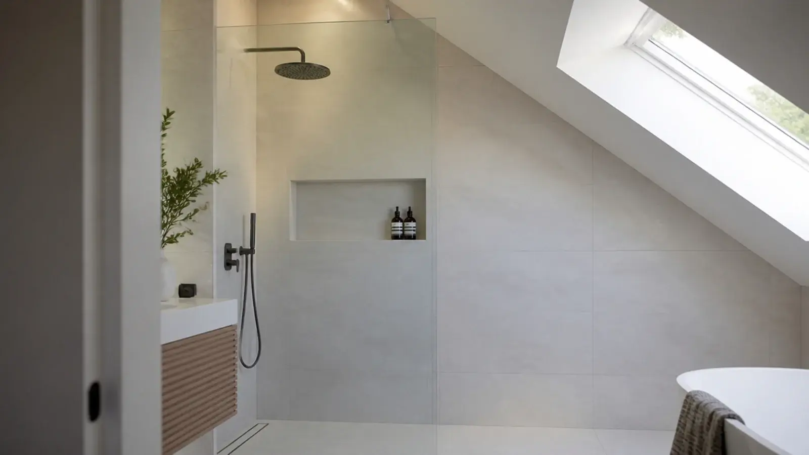 walk in shower positioned under the full height section of a loft ensuite
