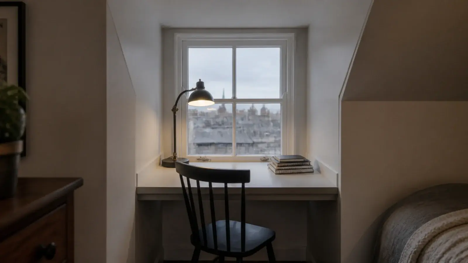 compact desk built into the square recess of an attic dormer window