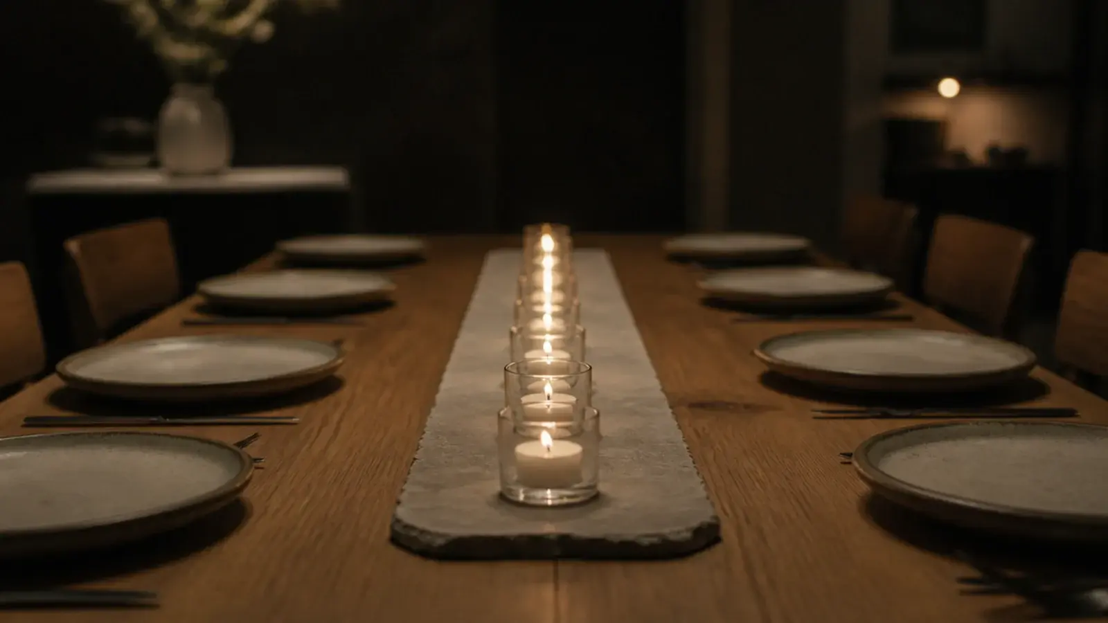row of tealights in small glasses running down a dining table center