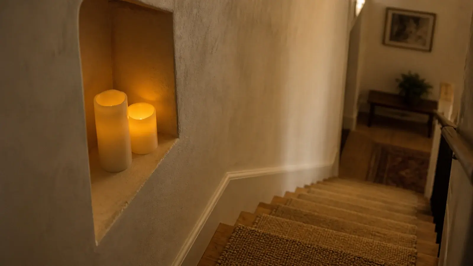 stairwell nook glowing with flameless candles beside oak treads