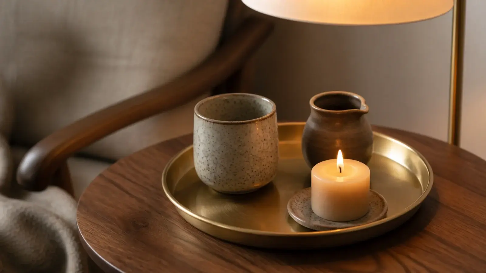 tea tray with stoneware cup beside candles on a corner side table