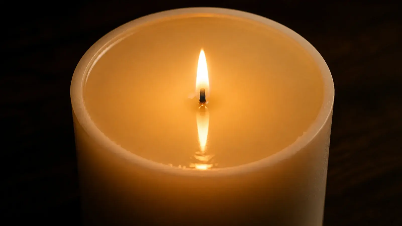 wide pillar candle with melted wax reaching its full outer edge