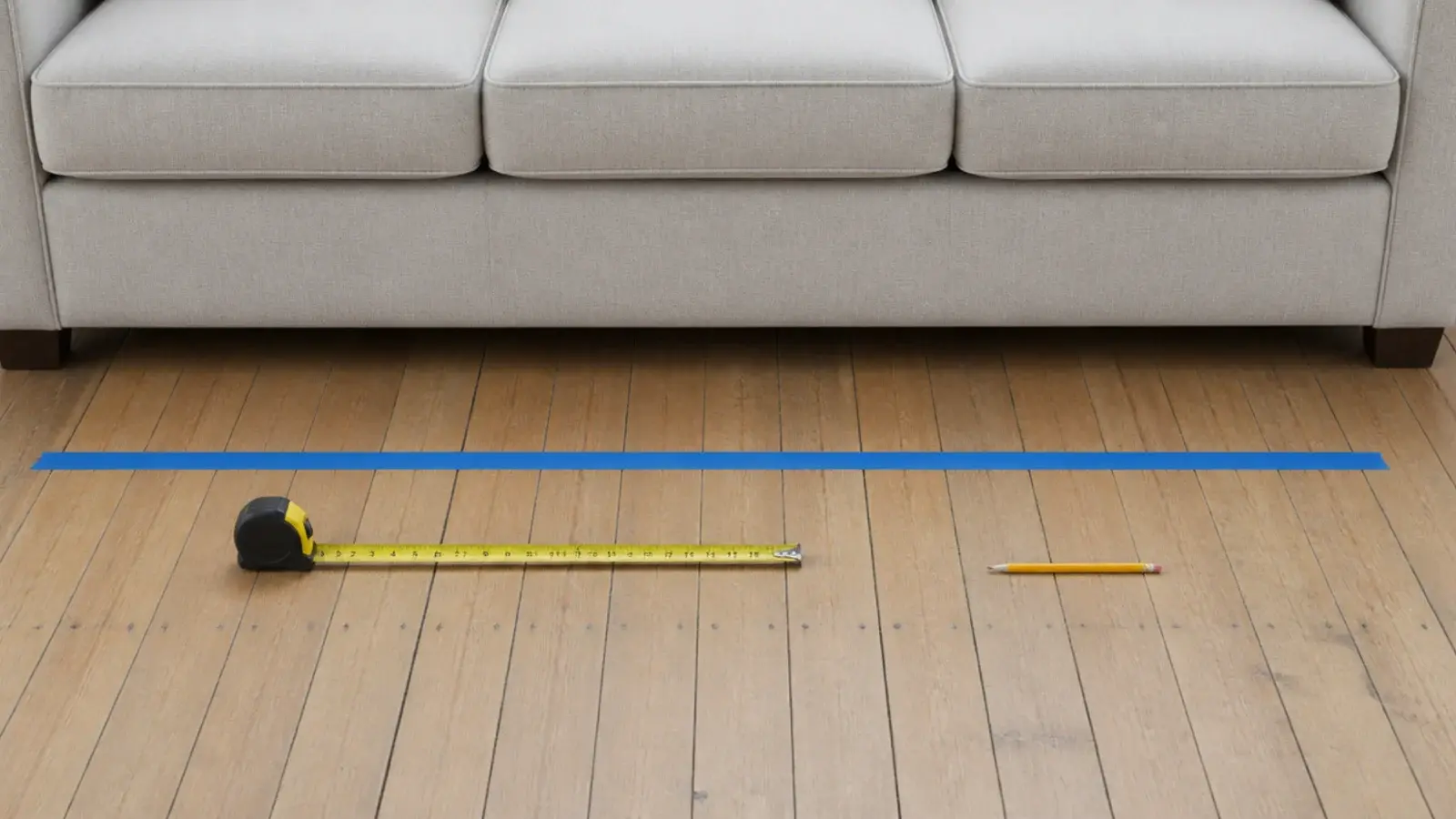 painters tape strip marking the walkway gap in front of a sofa