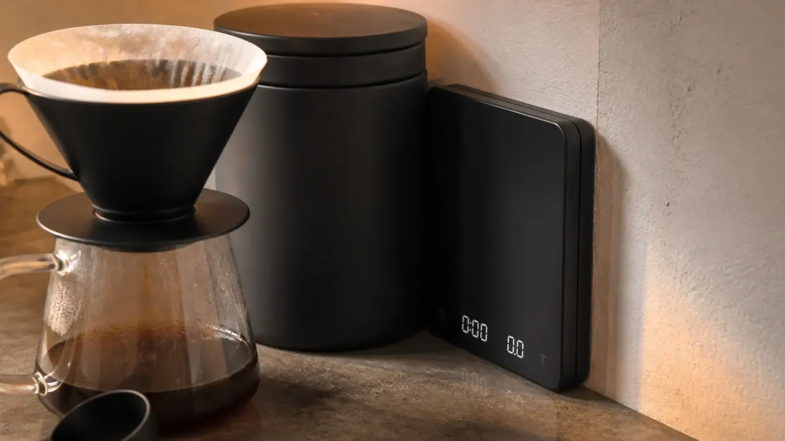 slim coffee scale standing upright in a gap beside a canister