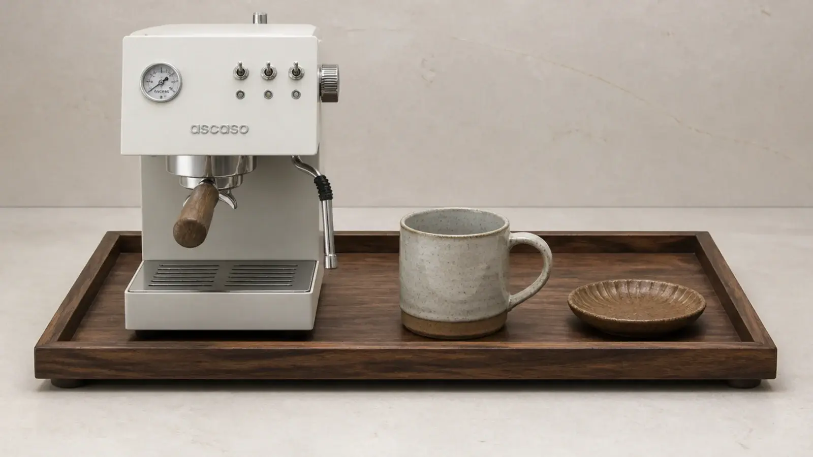 lipped walnut tray holding a coffee machine mug and small canister