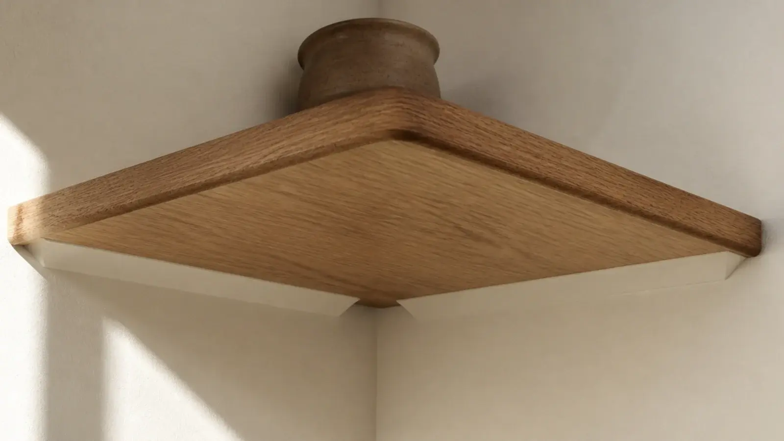 corner shelf with brackets painted to match the cream wall behind it