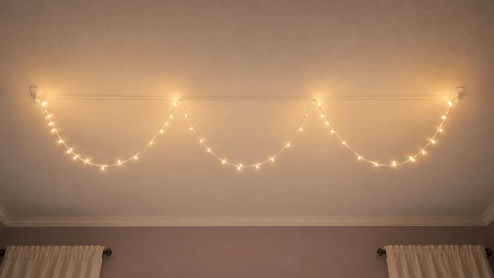 clear nylon line strung across a ceiling carrying a light strand