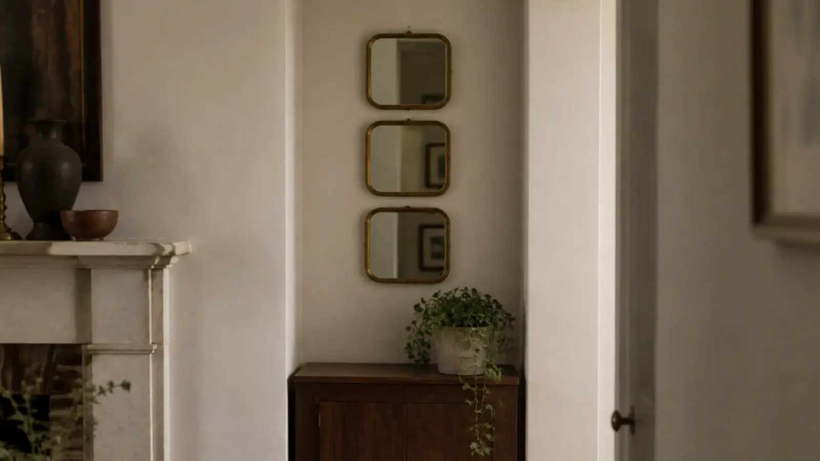 cluster of three small mirrors filling a narrow chimney breast alcove