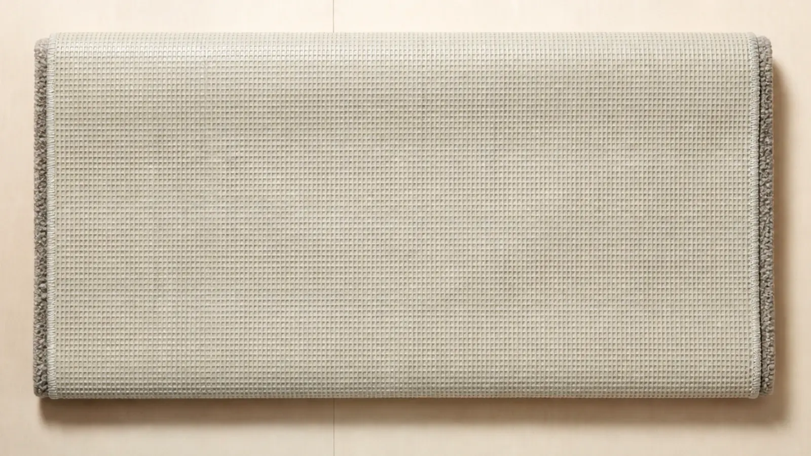 underside of a budget rug showing a stiff latex coated backing